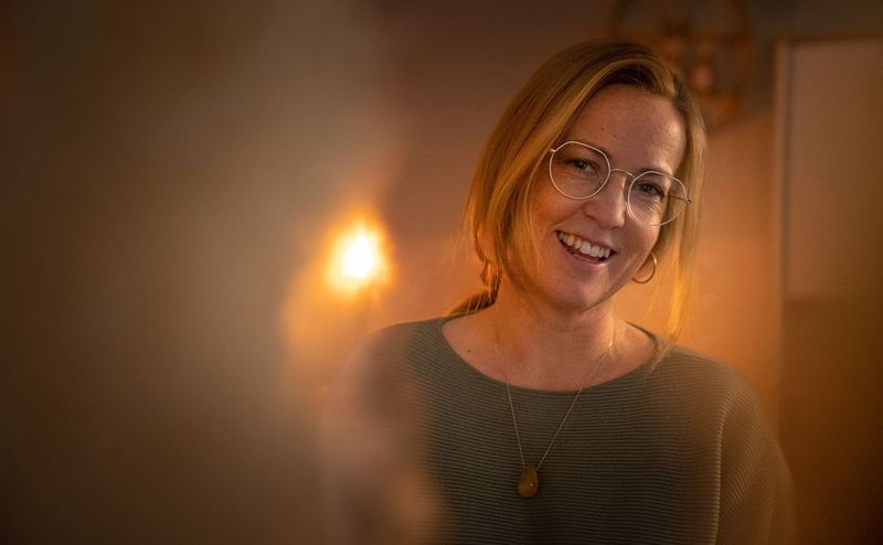 Lesley Lucas glimlacht in warm, gedempt licht